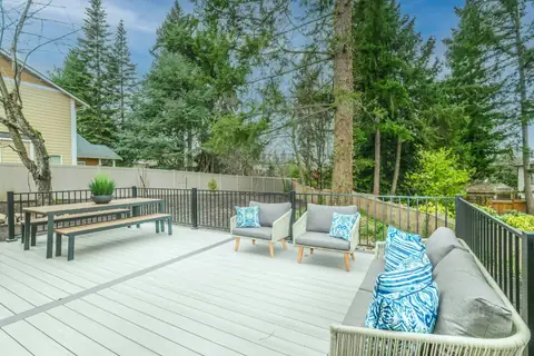Clean wooden deck with patio furniture and a backyard fence