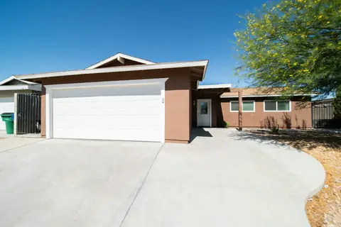 Wide clean concrete driveway leading up to a home garage